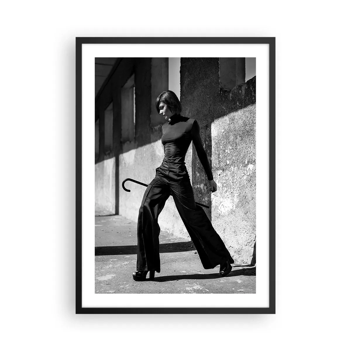 Póster en marco negro - Una mujer con un traje elegante y un bastón frente a una arquitectura austera. - 50x70cm - Elegancia urbana - Decoración de pared moderna para salón y dormitorio ARTTOR