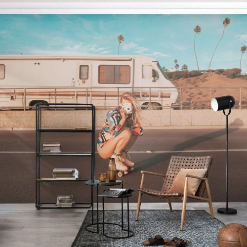 Fotomural Premium Sand - Una niña en patines con una cámara delante de una caravana. - 100x70cm - ¡Sonrían, por favor! - Decoración de pared moderna para salón y dormitorio ARTTOR