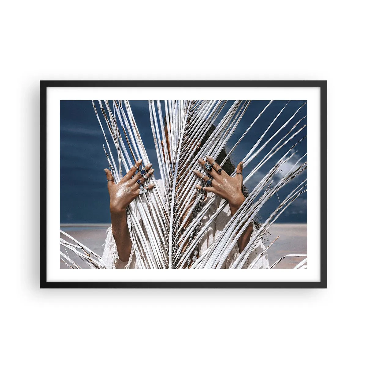 Póster en marco negro - Una mujer escondida detrás de hojas de palma con anillos en sus manos. - 70x50cm - ¿La mujer chamana? - Decoración de pared moderna para salón y dormitorio ARTTOR