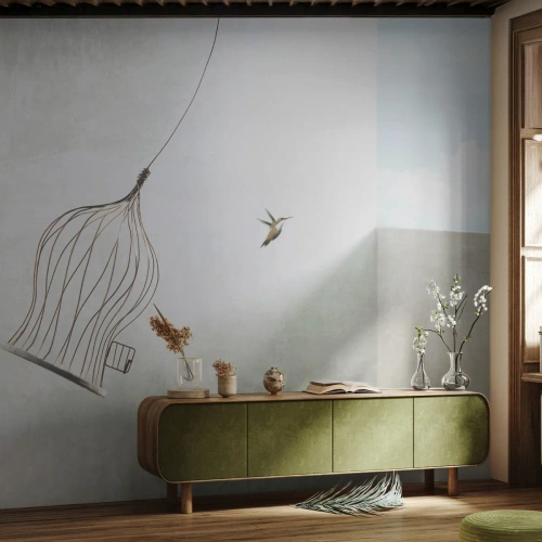 Fotomural Premium Sand - Un colibrí en vuelo con una jaula abierta contra el cielo. - 100x70cm - Aquí debo estar - Decoración de pared moderna para salón y dormitorio ARTTOR