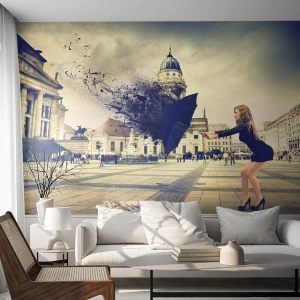 Fotomural Premium Sand - Mujer con paraguas disipándose en abstracción en la plaza - 100x70cm - Hay un viento tan... - Decoración de pared moderna para salón y dormitorio ARTTOR