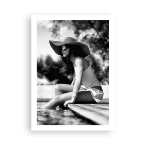 Póster - Una fotografía en blanco y negro de una mujer con sombrero sentada junto al agua. - 50x70cm - Un sueño de verano - Decoración de pared moderna para salón y dormitorio ARTTOR
