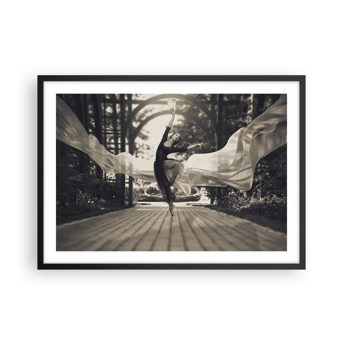 Póster en marco negro - Una bailarina con un vestido fluido realiza un salto frente a un jardín en blanco y negro como telón de fondo. - 70x50cm - Danza del espíritu del jardín - Decoración de pared moderna para salón y dormitorio ARTTOR