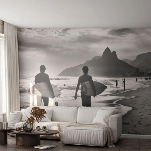Fotomural Standard Eco - Surfistas en la playa al atardecer en blanco y negro - 100x70cm - Samba para una ola - Decoración de pared moderna para salón y dormitorio ARTTOR