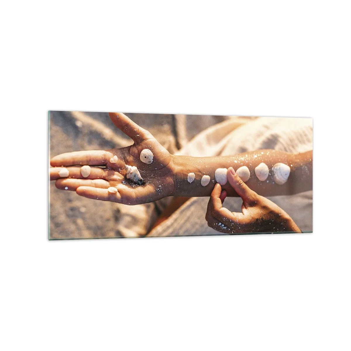 Cuadro sobre vidrio - Impresiones sobre Vidrio - Manos con conchas marinas dispuestas sobre el fondo de arena. - 120x50cm - La belleza al alcance de la mano - Decoración de pared moderna para salón y dormitorio ARTTOR