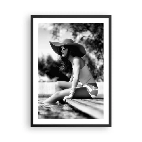 Póster en marco negro - Una fotografía en blanco y negro de una mujer con sombrero sentada junto al agua. - 50x70cm - Un sueño de verano - Decoración de pared moderna para salón y dormitorio ARTTOR