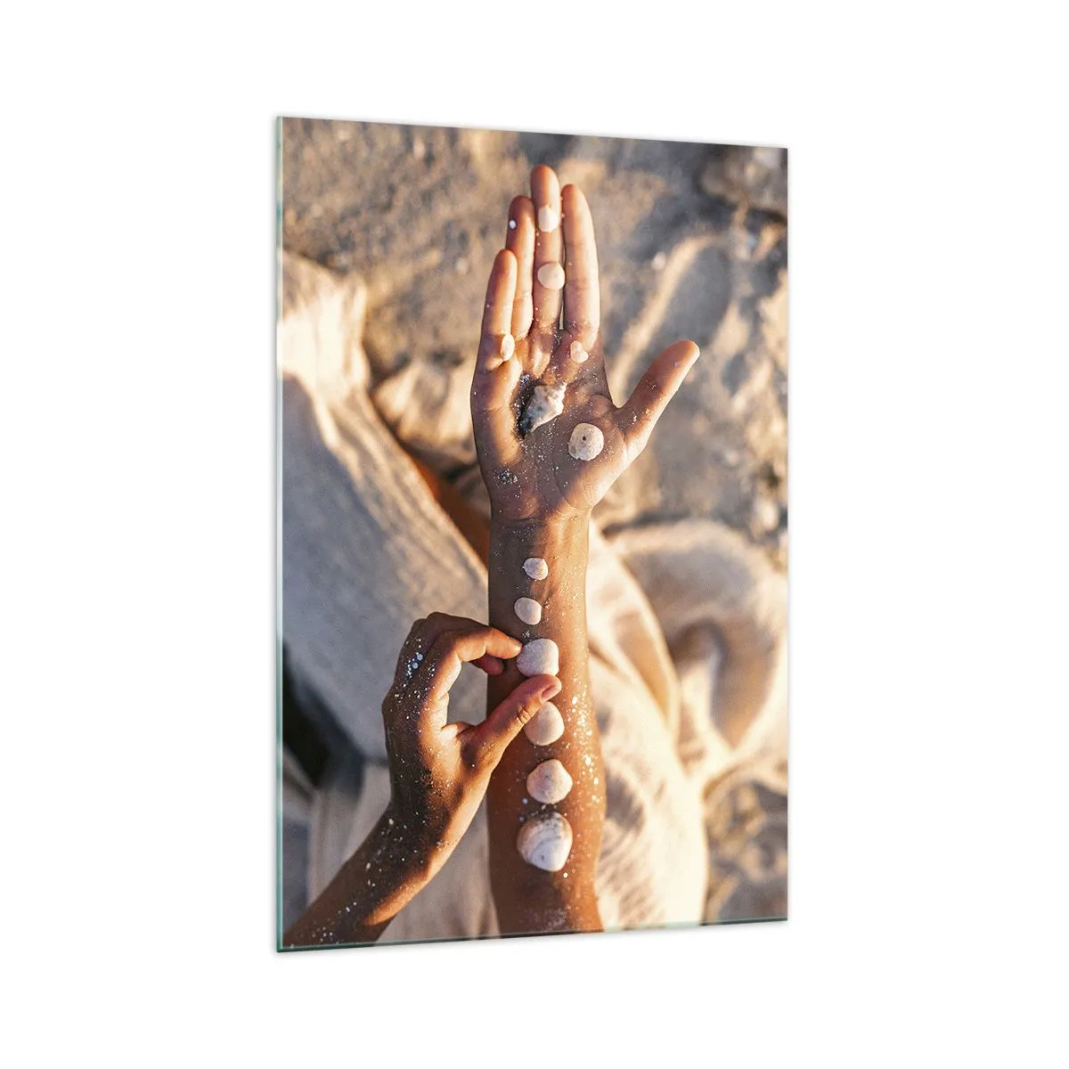 Cuadro sobre vidrio - Impresiones sobre Vidrio - Manos con conchas marinas dispuestas sobre el fondo de arena. - 70x100cm - La belleza al alcance de la mano - Decoración de pared moderna para salón y dormitorio ARTTOR
