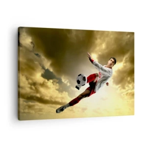 Cuadro sobre lienzo - Impresión de Imagen - Un jugador de fútbol en un salto dinámico pateando el balón contra el cielo. - 70x50cm - El cielo del fútbol - Decoración de pared moderna para salón y dormitorio ARTTOR